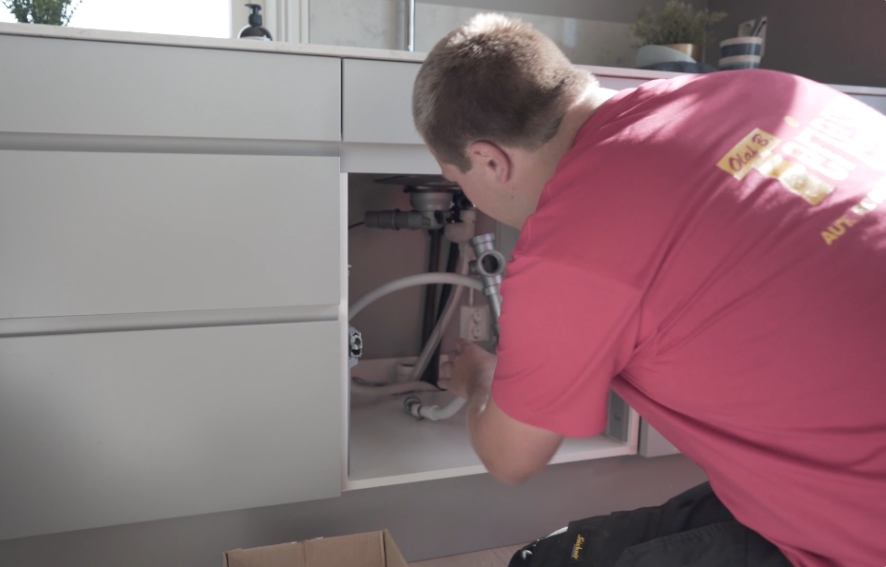 Rørlegger i arbeid med reparasjon og rørtilkoblinger i privat bolig